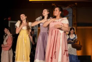 Students singing characterized as characters fairy tale during a school musical performance, highlighting vocal talent and artistic expression.