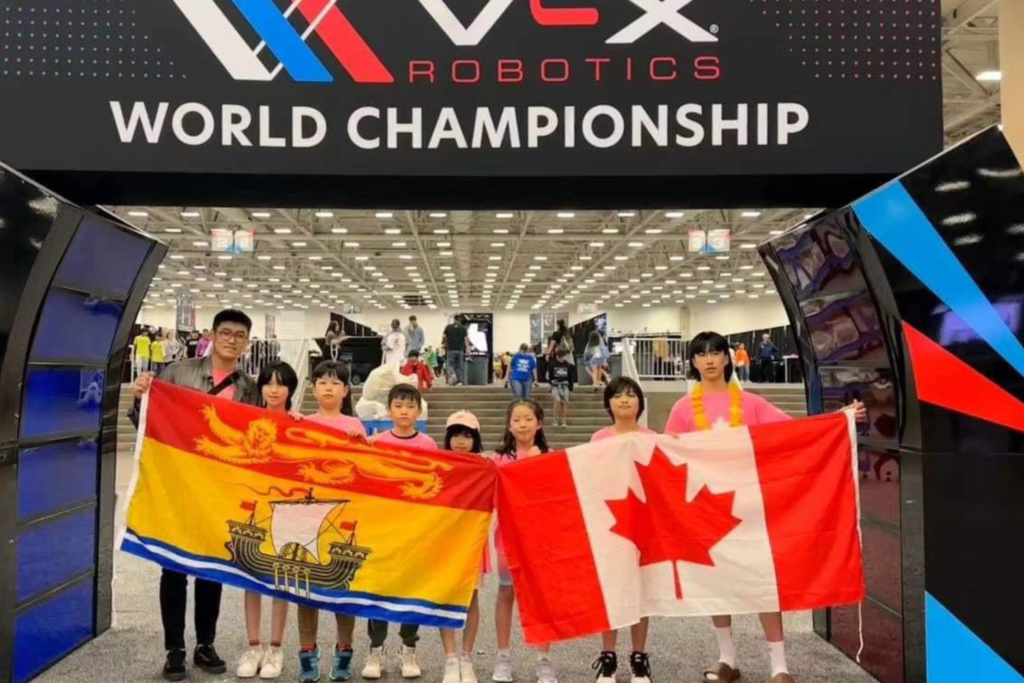 Group of students with Canadian and New Brunswick flags participating in the World Robotics Championship, representing the school's extracurricular activities.
