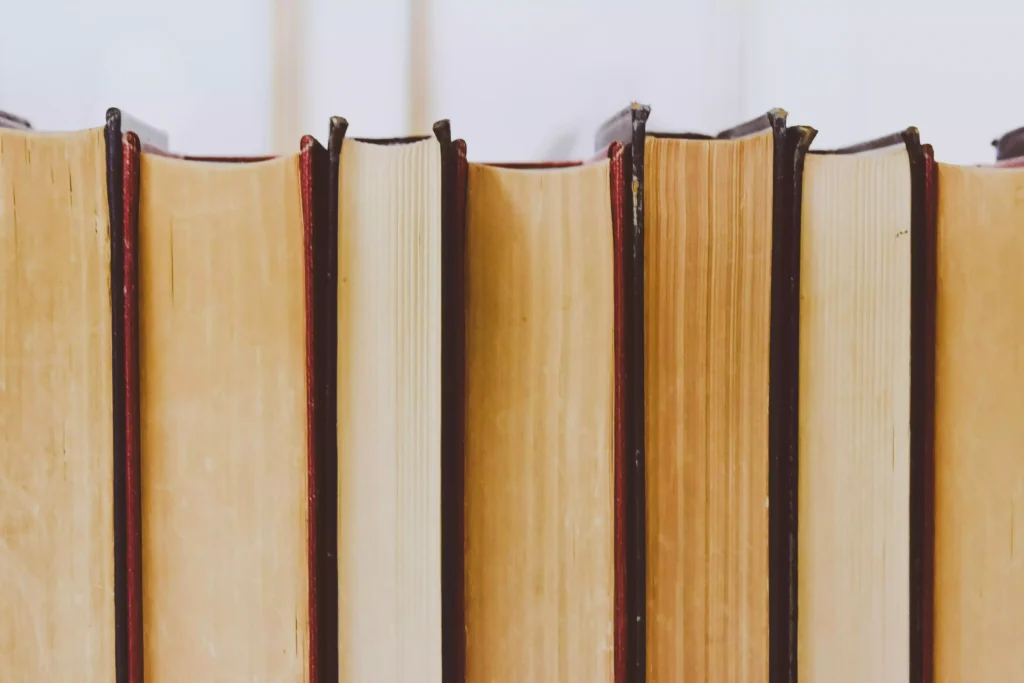 Conjunto de livros organizados verticalmente, simbolizando a busca pelo conhecimento acadêmico associada à plataforma UniversityNow.