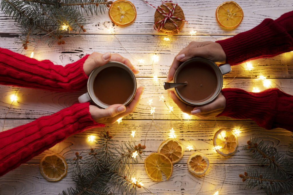 Dos personas brindando con chocolate caliente durante las vacaciones de Navidad