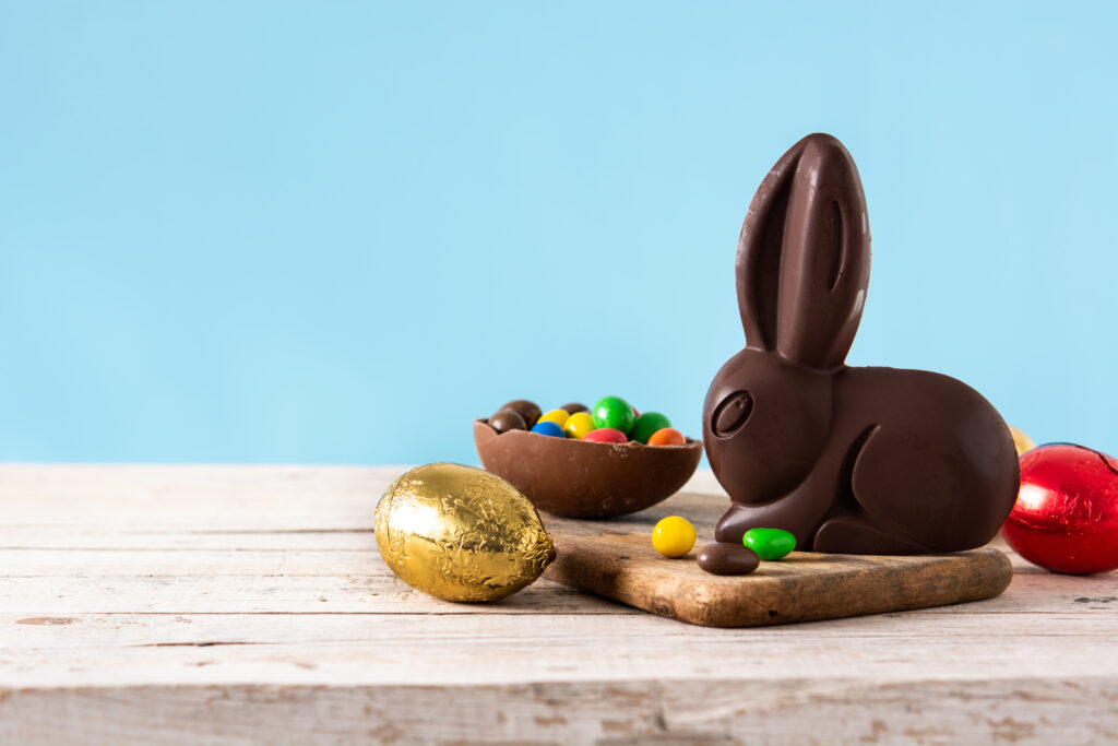 Conejo de chocolate con huevos de colores que representan las vacaciones de Pascua